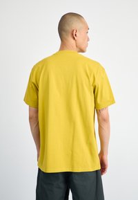Geel katoenen T-shirt met een regular fit, korte mouwen en een ronde hals. Heeft een zachte textuur en een eenvoudig ontwerp zonder patronen.