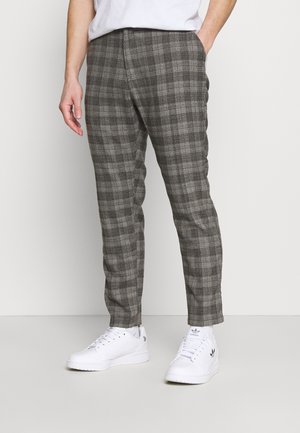 Grijze geruite broek met een getailleerde pasvorm, voorzien van een zachte textuur en zijzakken, gecombineerd met witte sneakers.