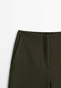 Pantalons vert olive foncé en tissu lisse et texturé, avec une taille plate, des poches latérales et des coutures discrètes.