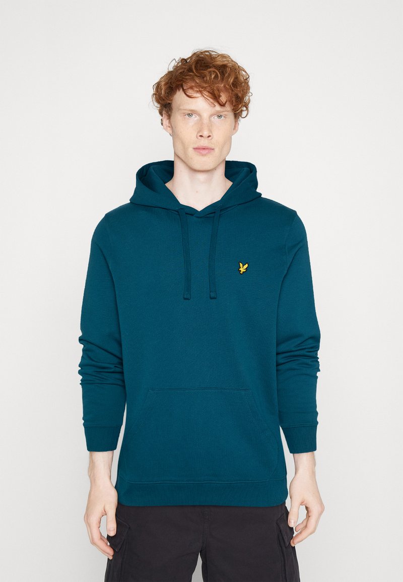 Hoodie bleu-vert en coton doux, avec une poche kangourou, une capuche à cordon et un petit logo jaune sur la poitrine.