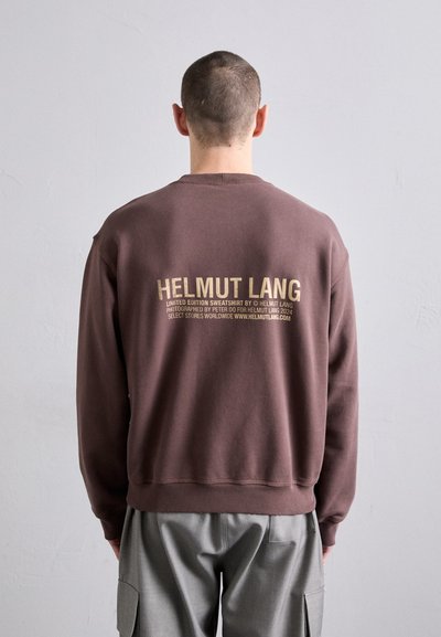 Sweatshirt de algodão castanho com gola redonda canelada. Apresenta um grande gráfico dourado "HELMUT LANG" nas costas. Textura suave e ajuste descontraído.