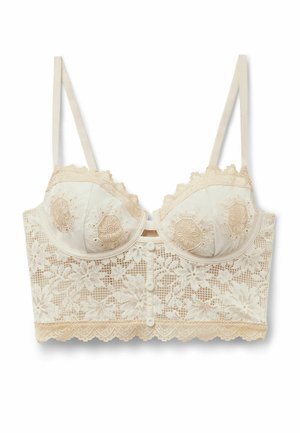 Lang cremefarvet blonde-BH med blomsterbroderi, justerbare stropper, bøjle-kopper og knapdetaljer på frontbåndet.