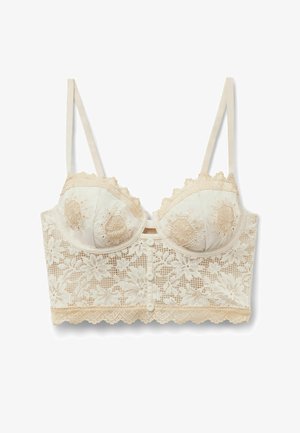 Dlouhá podprsenka krémové barvy s krajkou a květinovou výšivkou, nastavitelnými ramínky, kostěnými košíčky a knoflíkovými detaily na předním pásku.