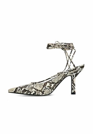 Slingback pump met spitse neus in slangenprint; voorzien van een enkelriempje, naaldhak en een gestructureerd oppervlak met zwart-witte patroonaccenten.