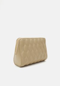 Beige steppelt clutch táska texturált mintázattal és arany cipzárral. Strukturált, háromszögletű formával rendelkezik.