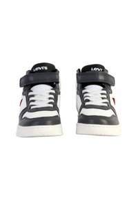 Sneakers alte in pelle grigia e bianca, con una fascia in velcro, lacci bianchi e un accento di logo rosso sul lato.