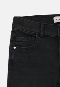 Black denim jeans with a front pocket, belt loops, and a small decorative stone on the pocket. Smooth texture and classic design.