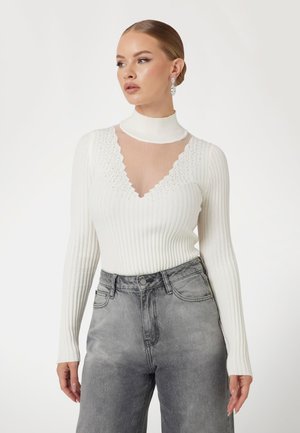 Witte geribbelde longsleeve bodysuit met een doorzichtig gaaspaneel en een geschulpte halslijn, gecombineerd met hoge taille grijze denim jeans. Algehele fitted design.