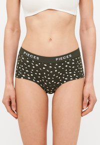 Carneira de roupa interior com um estampado floral, apresentando um logótipo branco "PIECES" na cintura elástica. O material parece ser suave e ajustado.