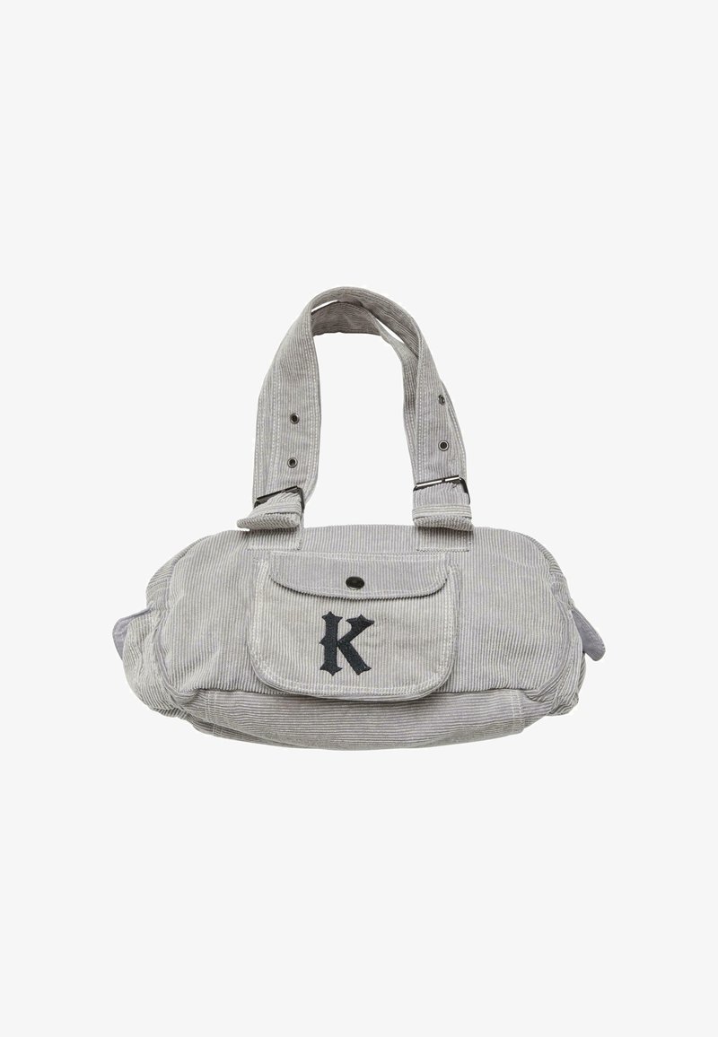 Borsa in corduroy grigio con due manici corti, una tasca frontale e una grande lettera nera "K". Presenta una chiusura con bottone e materiale testurizzato.