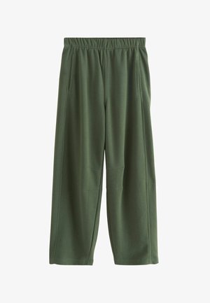 Pantalons de survêtement en tissu vert foncé, présentant un design à jambe large, une taille élastique, deux poches latérales et des coutures d'accent au niveau des genoux.