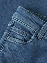 Jean en denim bleu avec une finition texturée, doté d'une poche avant, de surpiqûres contrastantes et d'un bouton en métal sur la ceinture.