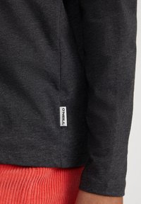 Langarmhemd in dunkelgrau aus weichem Stoff, mit einem kleinen weißen "O'Neill" Logo-Tag nahe dem Saum und einer glatten Textur.