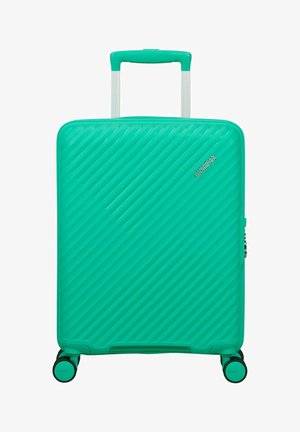 Valise rigide turquoise avec rainures diagonales, poignée rétractable et quatre roulettes pivotantes, de la marque American Tourister.