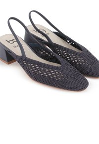 Zapatos de slingback negros trenzados con un tacón bajo y cuadrado y punta afilada. La parte superior presenta un diseño abierto, revelando un material texturizado debajo.