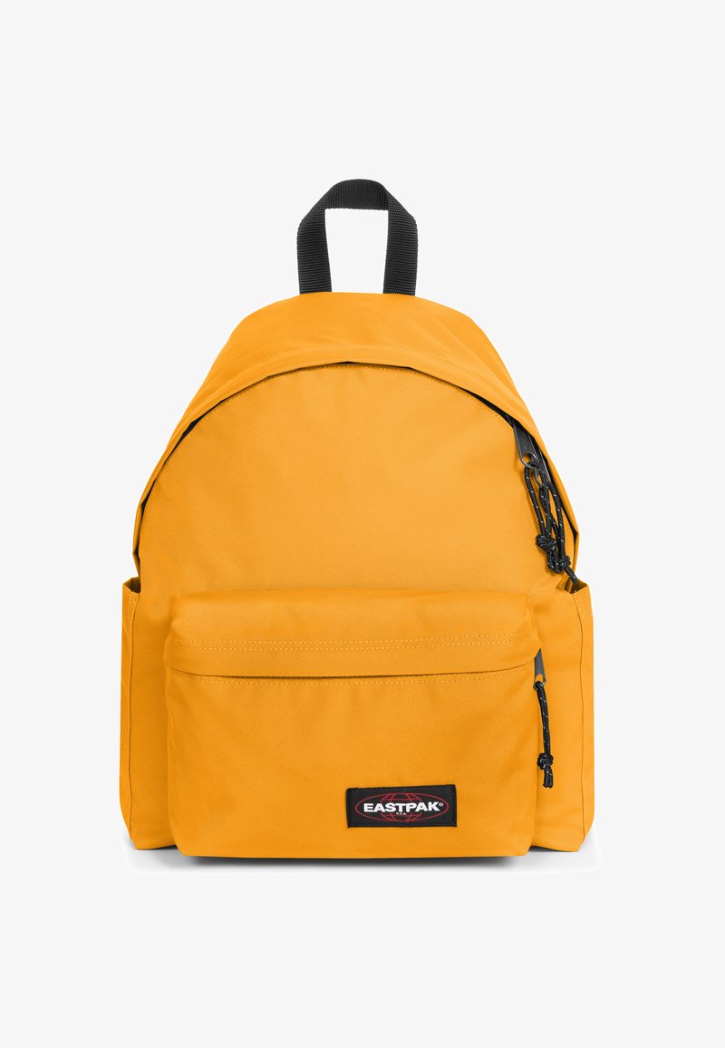 Sac à dos en tissu jaune de forme arrondie, avec une poche zippée à l'avant, une poignée supérieure et des accents noirs. Logo Eastpak visible.