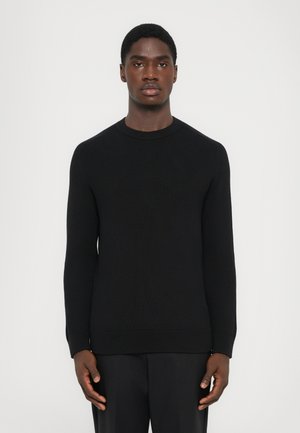 Schwarzer gerippter Strickpullover mit langen Ärmeln und Rundhalsausschnitt. Der Stoff hat eine strukturierte Oberfläche und eine enganliegende Silhouette.