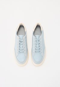 Light blue leather sneakers with a textured finish, round toe, lace-up design, and cream-colored rubber soles. Subtle perforations on the toe.