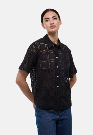 Chemise noire à manches courtes avec un motif floral découpé, fermeture à boutons et col. Tissu léger au toucher texturé.
