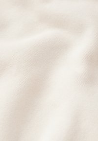 Tessuto bianco sporco con una sottile texture a costine, che mostra una morbida caduta e una superficie liscia. Il materiale appare leggero e traspirante.