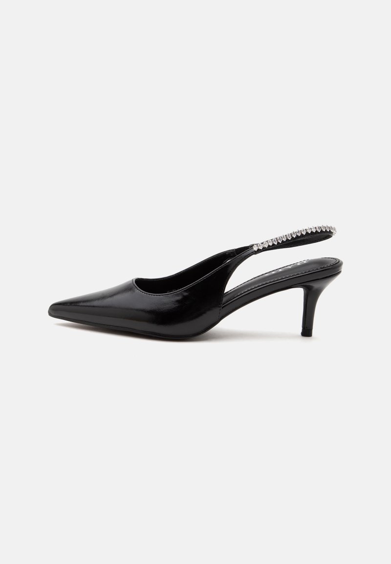 Chaussure noire à talon kitten avec bout pointu et bride arrière, ornée d'une rangée de petits strass transparents sur la bride, sur fond blanc.
