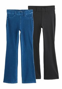 Kaks paari pükse: üks sinine denim, millel on laienevad jalad ja esitaskud, teine must sileda viimistluse ja kitseneva disainiga.