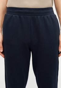 Σκούρο μπλε φόρμας με λεία υφή, με άνετη ελαστική ζώνη μέσης και πλαϊνές τσέπες, κατάλληλη για καθημερινή χρήση.