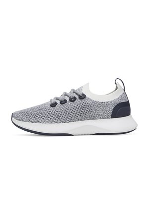 Grauer und weißer gestrickter Sportschuh mit schwarzen Ösen, weißer Sohle und schwarzem Fersenpatch, seitlich vor weißem Hintergrund gezeigt.