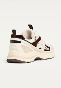 Chunky sneakers with a beige mesh upper, brown suede accents, textured detailing, and a rubber sole. Pull tab at the heel for easy wear.