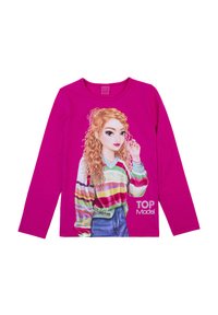 Maglietta a maniche lunghe rosa con un grafico di una ragazza dai capelli ricci biondi, che indossa un maglione a strisce multicolore sopra i jeans.
