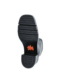 Suela de bota de goma negra con un patrón de relieve texturizado y un emblema naranja en el talón. Parte superior lisa con diseño de puntera redondeada.