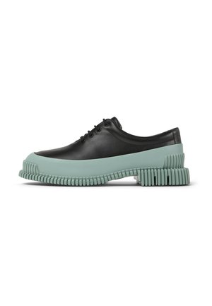 Black leather lace-up shoe with a chunky mint green rubber sole featuring ridged accents. The design has a rounded toe and smooth texture.
