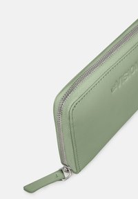 Green leather wallet with a textured finish, featuring a silver zipper and a secure pull tab. Embossed branding on the exterior.