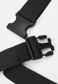 Cintura nera in nylon con doppi fermagli in plastica. Presenta una cinghia texturizzata e una lunghezza regolabile per una vestibilità sicura. Design semplice e funzionale.