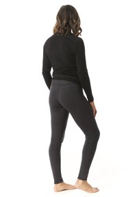 Haut à manches longues noir et leggings gris foncé, design ajusté, texture douce et longueur cheville, portés pieds nus, photographiés de derrière.