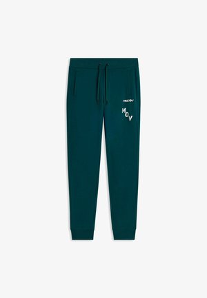 Pantalons de survêtement en bleu sarcelle avec taille à cordon, poches latérales, poignets côtelés et texte blanc "FREDDY" et "MOV" sur la cuisse droite.