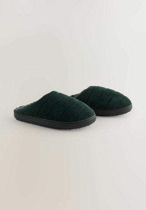 Green corduroy slippers with a textured surface, soft lining, and black rubber soles, featuring a slip-on design and a rounded shape.