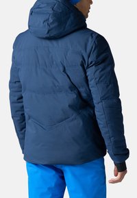 Marineblaue isolierte Jacke mit Kapuze, ausgestattet mit Nähdetails und einem strukturierten Rückendesign. Glatte Textur, strapazierfähiges Material.