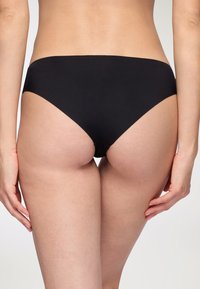 Parte inferiore di bikini nera con design a vita bassa, tessuto liscio e taglio minimalista, che mostra una finitura semplice e senza cuciture.