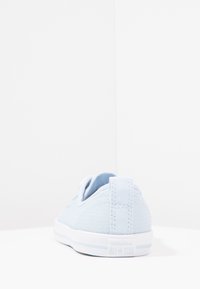 Jasnoniebieskie płócienne sneaker'y z teksturowaną powierzchnią, białą gumową podeszwą i kontrastową metką logo z tyłu. Klasyczny niski krój.