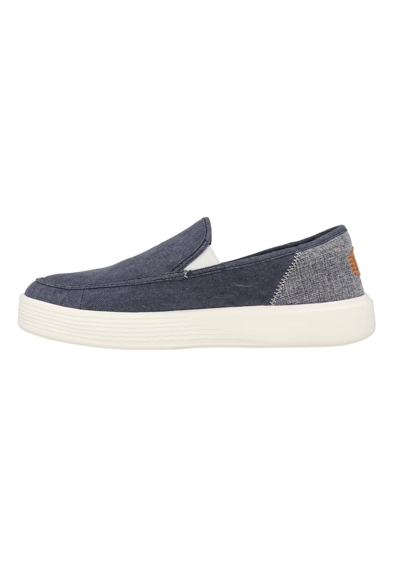 Marine slip-on schoenen met een textiele bovenkant, elastische inzet voor een goede pasvorm en een witte rubberen zool. Bevat een contrasterend achterpaneel.