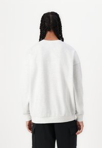 Grå sweatshirt med lange ærmer, rund halsudskæring og ribstrikkede manchetter og kant. Fremstillet af blødt stof med et minimalistisk design.