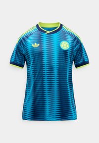 Maillot de football à manches courtes aux motifs bleu et marine avec bordure jaune néon, logo Adidas sur la poitrine droite et emblème de la fédération colombienne de football sur la gauche.