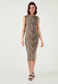 Leopard print fitted dress with cap sleeves, knee-length, featuring a smooth fabric texture and a rounded neckline. Worn with strappy black sandals.