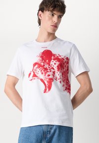 White cotton t-shirt featuring a large red cheetah graphic on the front, short sleeves, and a crew neckline, with "HUGO" above the graphic.