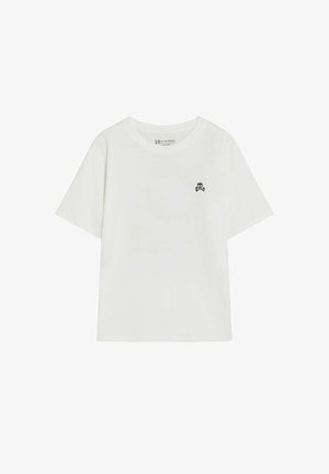 Camiseta blanca de manga corta con pequeño logo negro de calavera y huesos cruzados en el lado izquierdo del pecho, cuello redondo y ajuste holgado.
