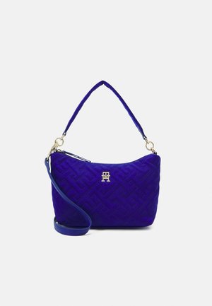 Bolso de hombro de color azul profundo acolchado con herrajes dorados, patrón geométrico y con asa corta y correa larga desmontable.