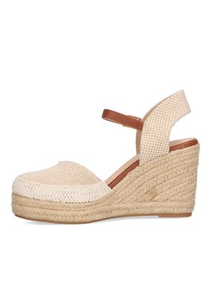 Beige kilehøje sandaler med en vævet overdel, åben tå og en brun ankerrrem. Hælen er lavet af flettet jute, hvilket tilføjer tekstur og højde.