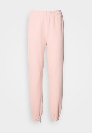 Lyserosa elastisk midjebånd joggebukser med tapered ben og samlet elastisk mansjetter ved anklene på en enkel bakgrunn.