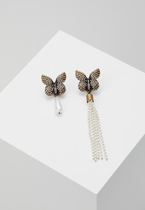 Asymmetrische Ohrringe in Schmetterlingsform mit Strasssteinen; einer hat einen hängenden Perltropfen, der andere mehrere Perlenquasten.